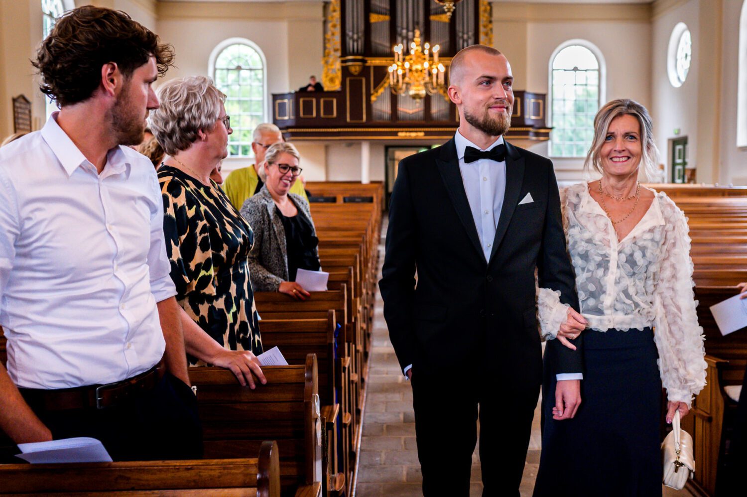 Bruidegom en moeder aankomst kerkelijke ceremonie